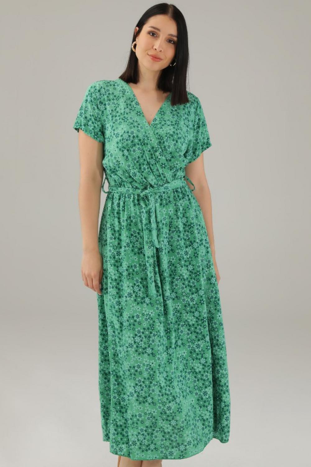 The dress is green with a floral print 15-5098