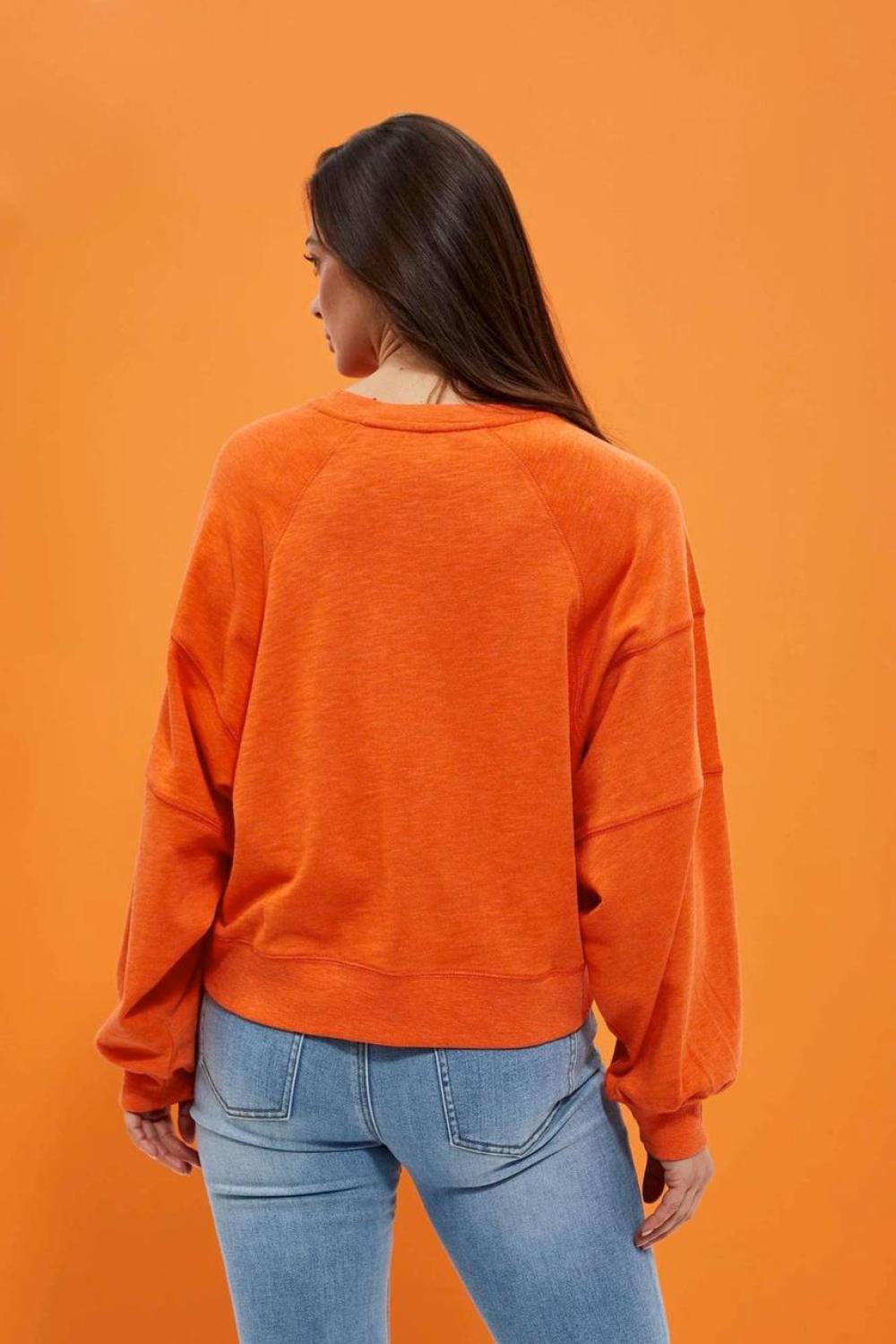 women's sweatshirt is presented in a bright orange color