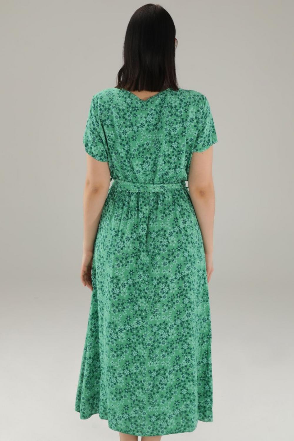 The dress is green with a floral print 15-5098