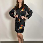 The dress is black with a colorful NocheMio print