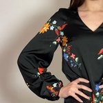 The dress is black with a colorful NocheMio print