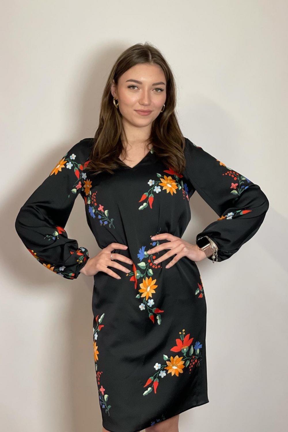 The dress is black with a colorful NocheMio print